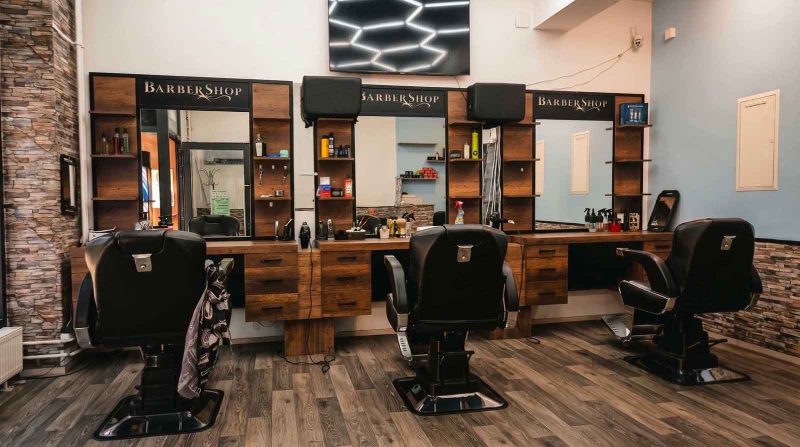 Innenraum von Zerey Herren Coiffeur mit Barbierstühlen und Hexagon-Licht